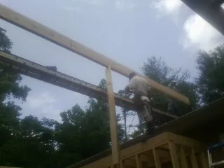 Carpenter setting a ridge beam over a new addition frame — Ice Dam Removal by Roofing Brothers in Kenbridge