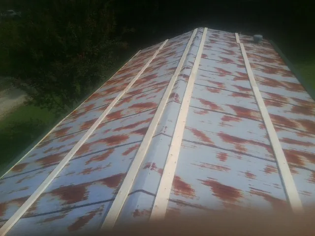 Rusted metal roof panels with new wood purlins before replacement — Storm Damage Roof Repair in Kenbridge by Roofing Brothers