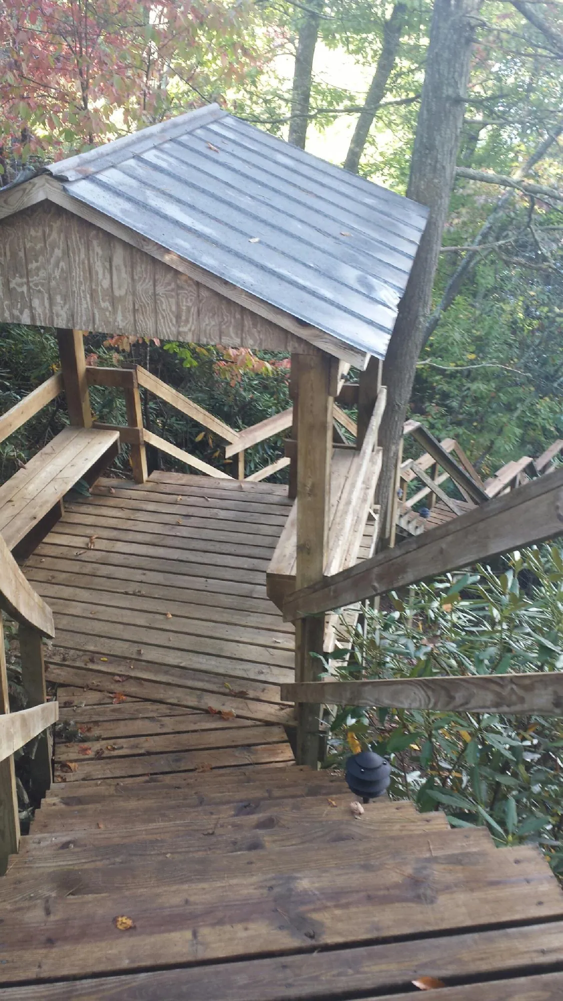 Metal roofed shelter over wooden steps on a wooded walkway — Skylight Repair & Installation work by our crew in Kenbridge