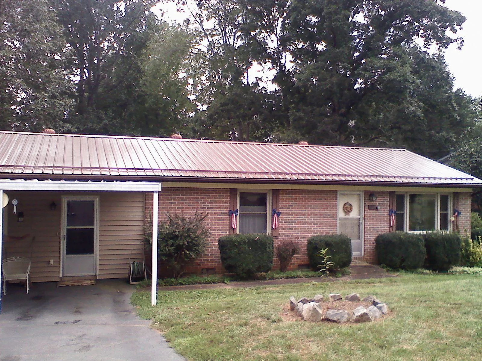 Bronze metal roof and carport on a brick ranch home — Roof Repair work by our crew in Kenbridge